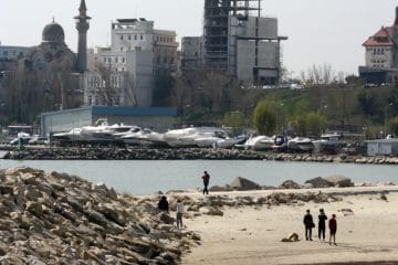 a group of people standing on top of a sandy beach
