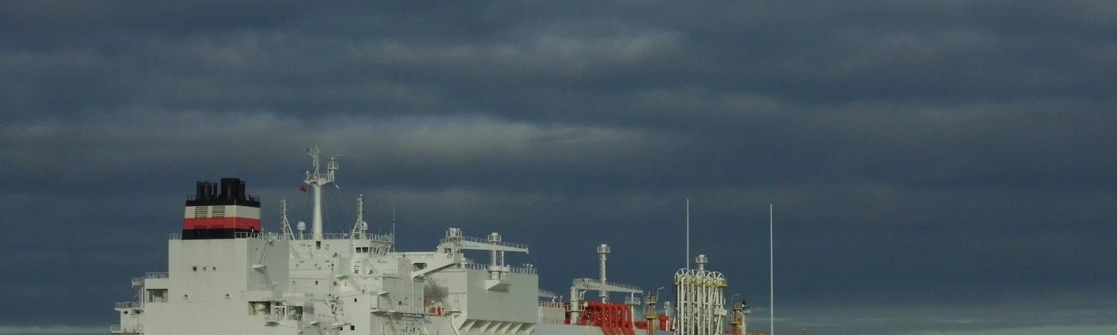 a large red and white ship in a body of water