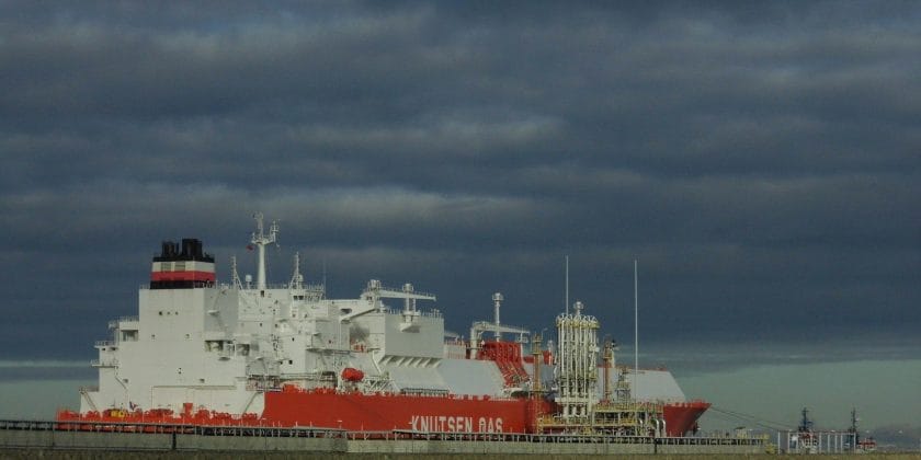 a large red and white ship in a body of water