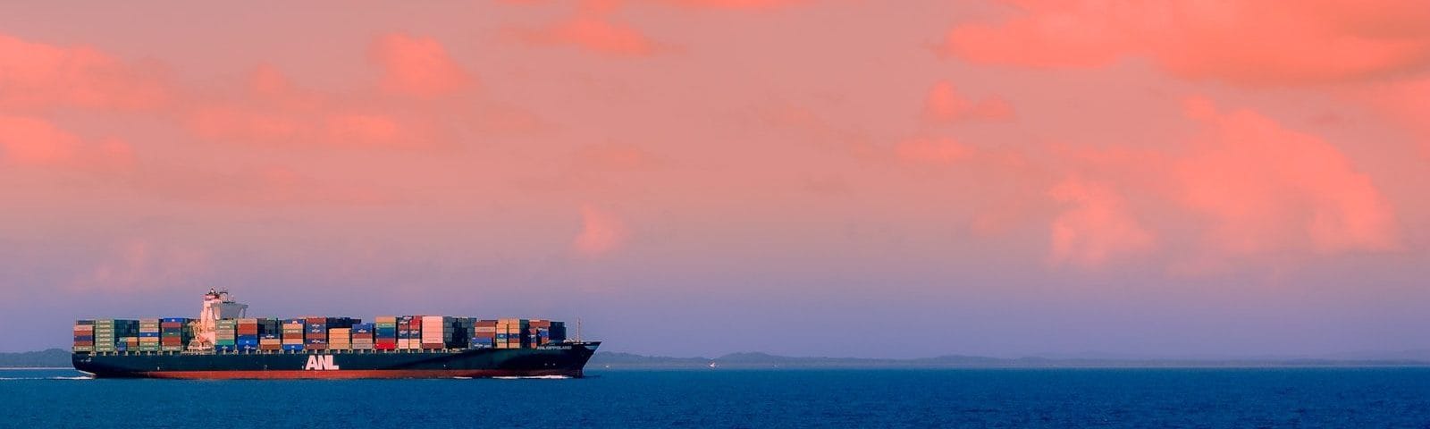 cargo ship on sea under cloudy sky during daytime