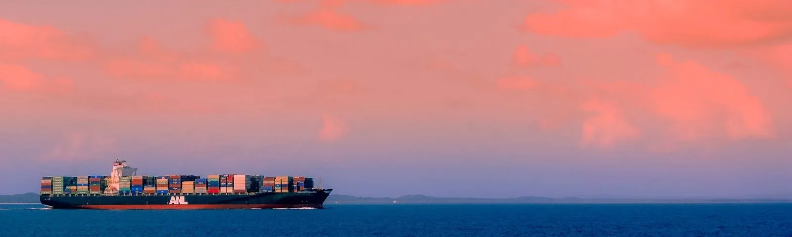 cargo ship on sea under cloudy sky during daytime