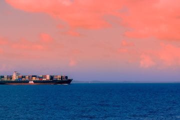cargo ship on sea under cloudy sky during daytime