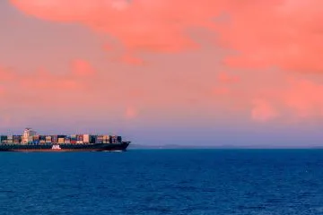 cargo ship on sea under cloudy sky during daytime