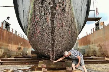 a man working on a large boat in a dry dock